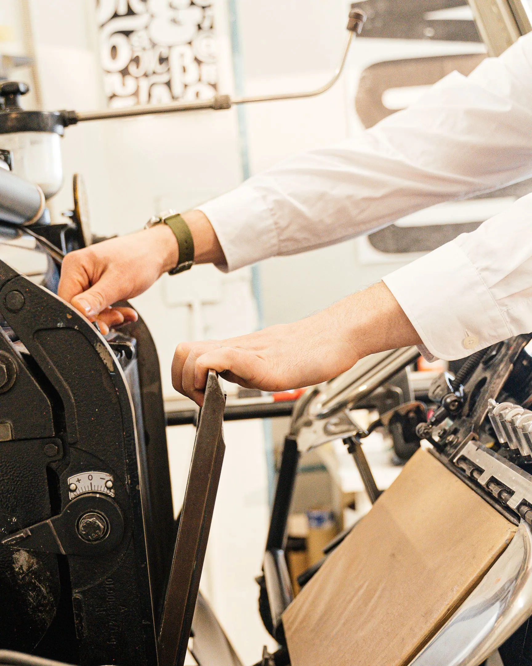 Hands working the feed of a printing press